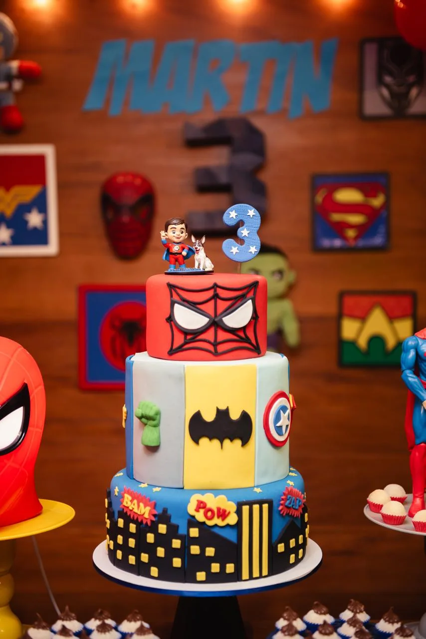 Bolo de aniversário de três andares com a miniatura personalizada do Martin no topo, ao lado da vela do número 3