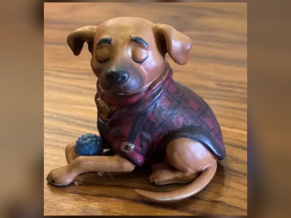 Uma das miniaturas de cachorro da Maria Christina, pintada à mão e fotografada sobre uma mesa
