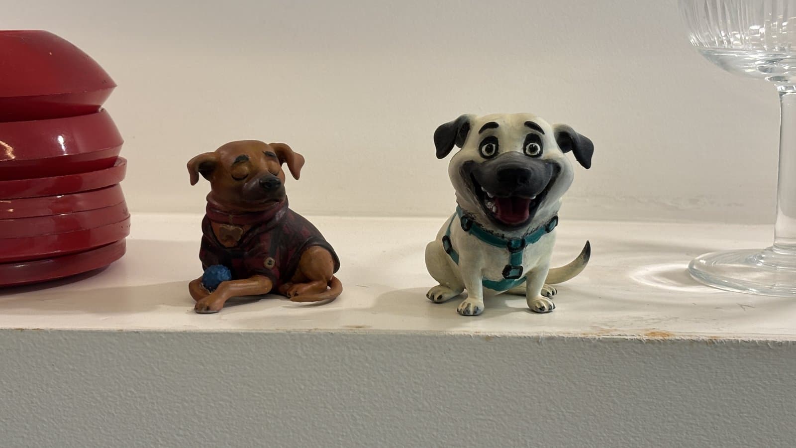 As duas miniaturas de cachorro da Maria Christina, decorando a prateleira da casa dela